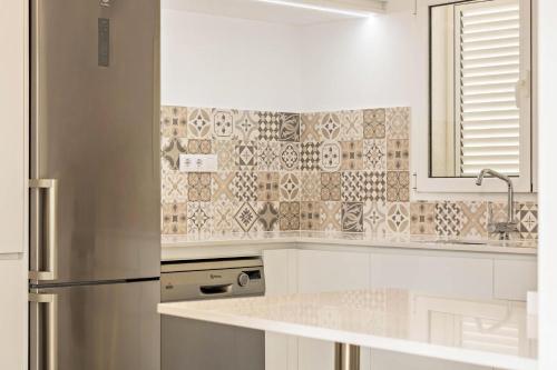 圣布里希达Casa del Monte的厨房配有白色橱柜和不锈钢冰箱