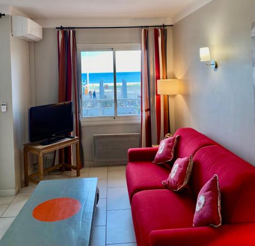 鲁西隆地区卡内Appartement Front de Mer的客厅配有红色沙发和电视