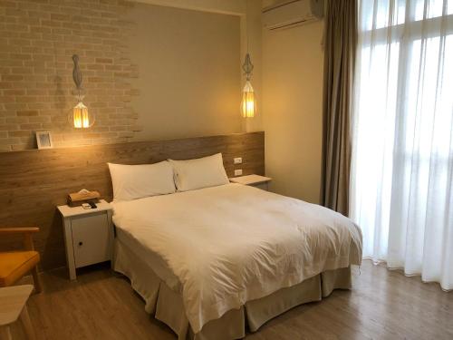 台东晓的卧室配有白色的床和砖墙