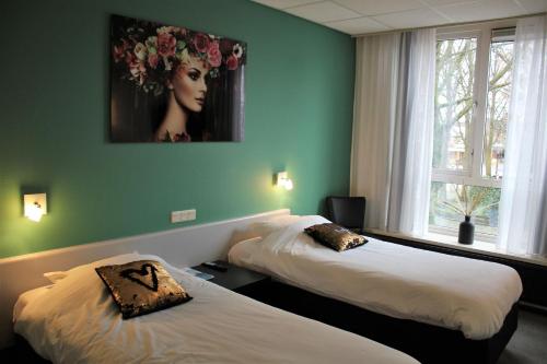 阿斯米尔德容格希特耶斯餐厅酒店的墙上画画的房间里设有两张床