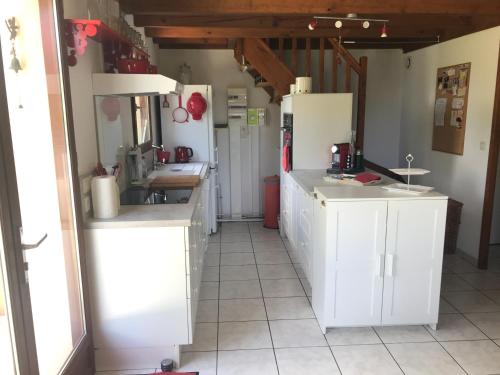 波讷地区圣朱利安Maison de vacances village Océlandes的一间厨房,内设白色橱柜和电器