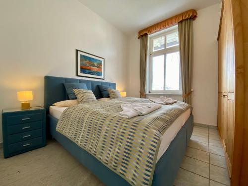 诺伊霍夫Villa Caprivi - Ferienwohnung 6的一间卧室配有一张带蓝色床头板的床和窗户