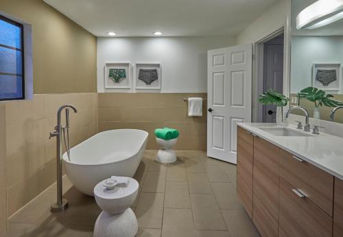 棕榈泉Descanso Resort, A Men's Resort的带浴缸、卫生间和盥洗盆的浴室