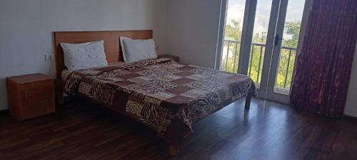 科代卡纳尔Kumaragiri Cottages Kodaikanal的一间卧室设有一张床和一个大窗户