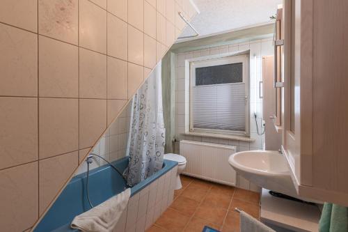 萨加尔德Ferienwohnung Am Kreidebach的一间带水槽和卫生间的浴室以及窗户。