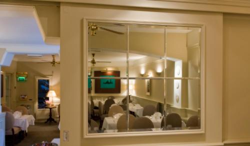 约尔阿赫尼斯联排别墅酒店和海鲜餐厅的一间透过窗户配有桌椅的用餐室