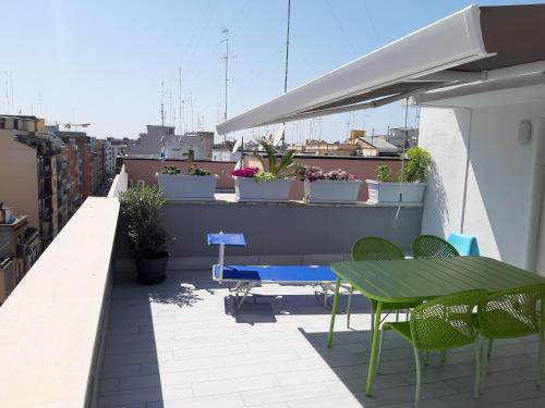 巴里Attico Con Terrazza A Bari的屋顶上带桌椅的天井
