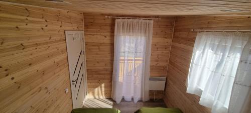 CireşuCăsuța de la luncă的小房间设有木墙和2个窗户