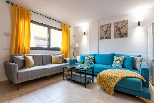 科蒂略Casa Cotillo 13 next to Los Lagos Beach Highspeed Wifi的客厅配有蓝色的沙发和桌子