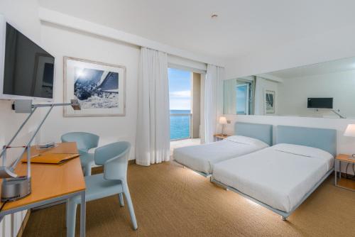 的里雅斯特Hotel Miramare - Adults Only的酒店客房带一张床铺、一张书桌和一间卧室