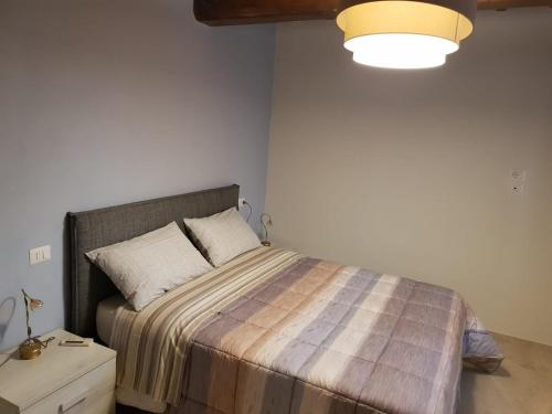托迪Agriturismo Villa al piano的一间卧室配有带条纹毯子的床