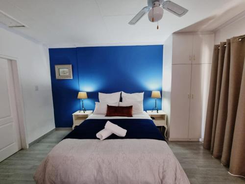 纽卡斯尔The Noble Dew Guest House的一间卧室设有一张蓝色墙壁的大床