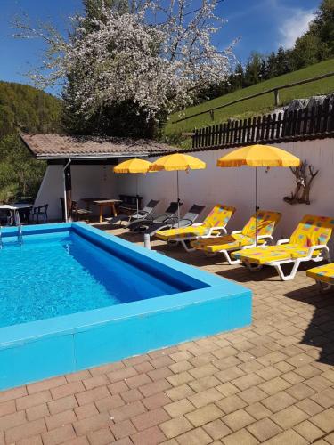 茵特斯托德Backer-Ferdl Panzio的游泳池配有黄色椅子和遮阳伞