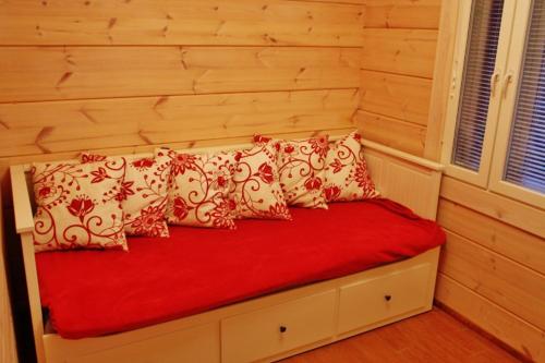 萨翁林纳SaimaanHelmi的一张带红色和白色枕头的床