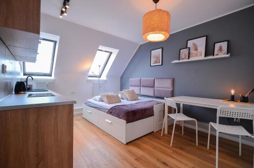 格但斯克CITYSTAY Brzezno Studio 3 min do plaży的一间带一张床和一张书桌的卧室和一间厨房
