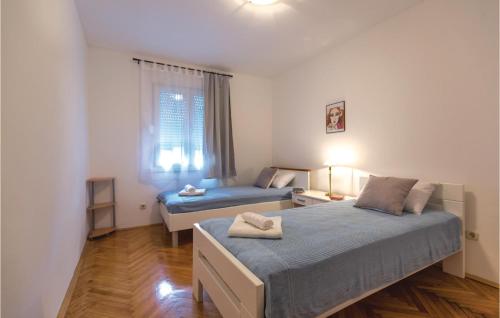 普洛切Awesome Apartment In Ploce With Kitchen的一间卧室设有两张床和窗户。