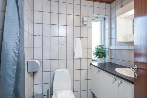 腓特烈港Hotel Frederikshavn的白色瓷砖浴室设有卫生间和水槽