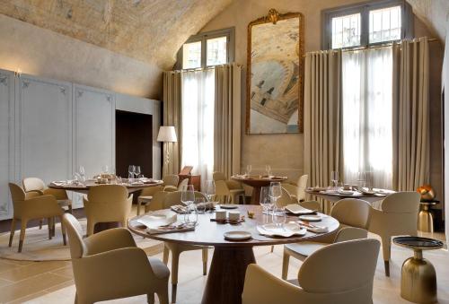 蒙彼利埃Hôtel Richer De Belleval - Relais & Châteaux的用餐室设有桌椅和窗户。