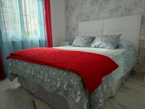 多列毛利诺斯CARIHUELA BEACH的一间卧室配有一张带红色毯子的床
