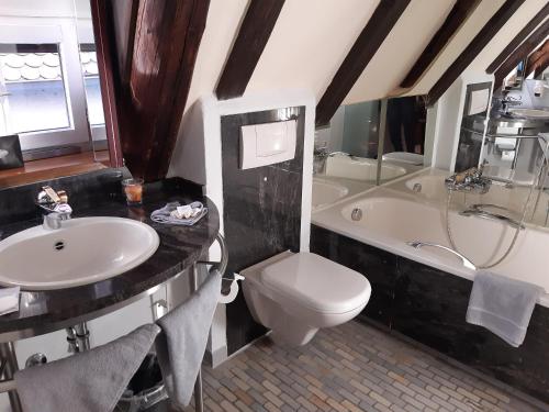 乌尔姆Hotel Schiefes Haus的浴室配有盥洗盆、卫生间和浴缸。