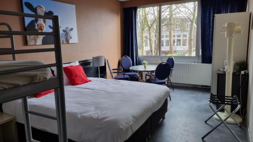 温斯霍滕City Hotel Winschoten的一间卧室配有一张双层床和一张桌子及椅子。