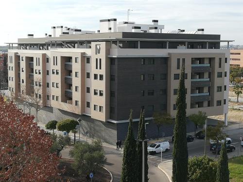 博尔穆霍斯Apartamento Servet, parking gratuito, a 5 minutos de Sevilla的一座大型建筑,前面有汽车停放