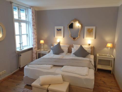 石勒苏益格Hotel Bed & Breakfast am Dom的卧室配有一张白色大床和两个窗户