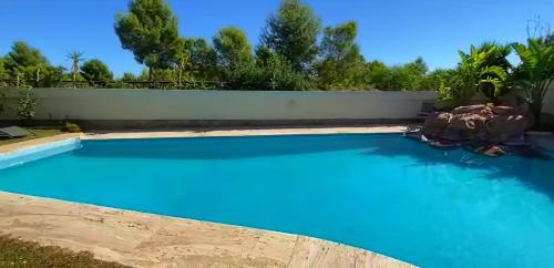 贝尼多姆VILLA Bed and Breakfast - kitchen, Pool, Barbecue and Large garden的后院的蓝色海水游泳池