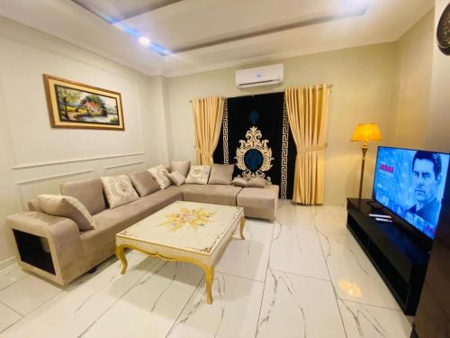 拉瓦尔品第Holidazzle Serviced Apartments Bahria Town的带沙发和电视的客厅