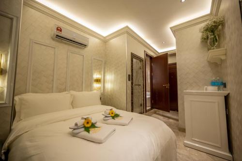 哥打京那巴鲁A Residence @ Between Hilton & Cititel Hotel的一间卧室配有一张大白色的床,上面有两个盘子
