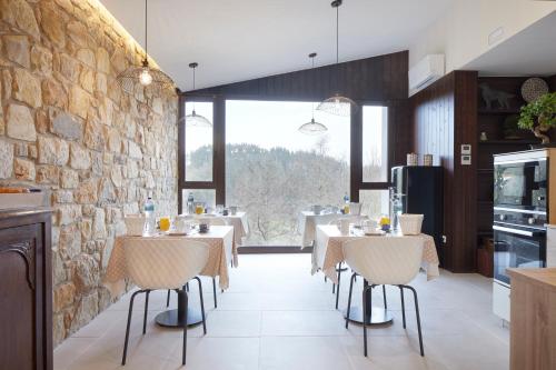 埃尔戈伊瓦尔Casa Rural Akei - Basque Stay的一间带桌椅和石墙的餐厅