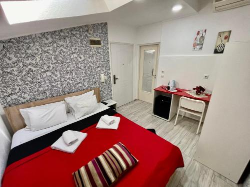 克拉古耶瓦茨Apartments Aleksandra的一间卧室配有红色的床和红色毯子