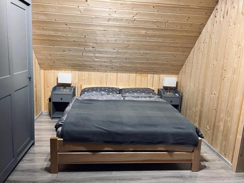 WycinkiDomki w Borach的一间卧室配有一张带2个床头柜的大床