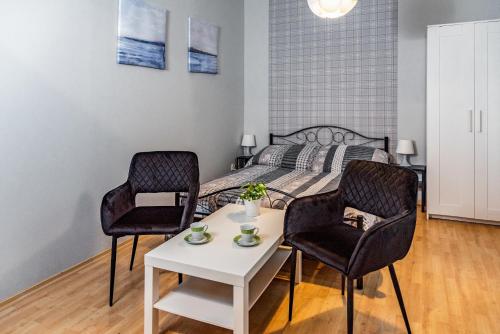 韦巴Ośrodek Wypoczynkowy Relaks i Apartamenty的一间卧室配有一张床、两把椅子和一张桌子