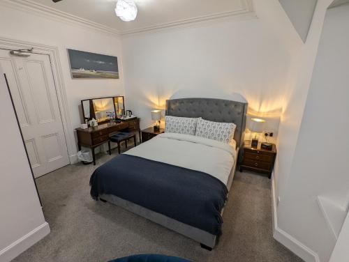 因弗内斯Cambeth Lodge的一间卧室配有一张床、一张桌子和一张四柱床。