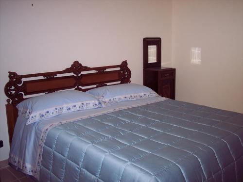 蒙特堡B&B Tramonto d'Oro的一间卧室配有一张蓝色的床和木制床头板