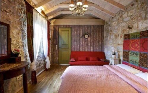 埃利尼科伊莱恩酒店的一间卧室配有红色的床和一张沙发