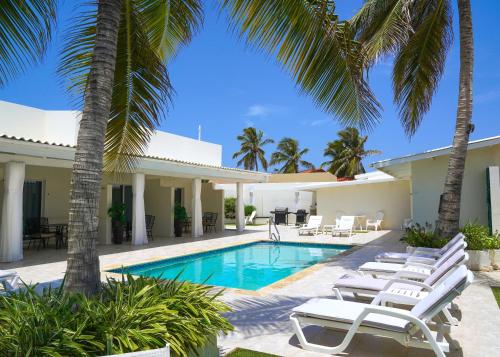 棕榈滩Yoyita Suites Aruba Villa的一座别墅,设有游泳池和棕榈树