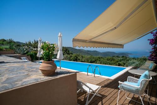 斯基亚索斯镇Luxury villa + guest house couchers de soleil mer的别墅 - 带游泳池和带遮阳伞的庭院