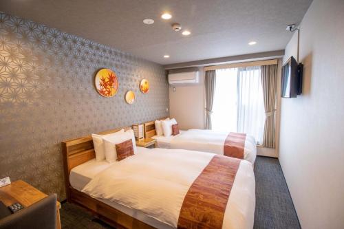 京都Stay SAKURA Kyoto Gion North的酒店客房设有两张床和电视。