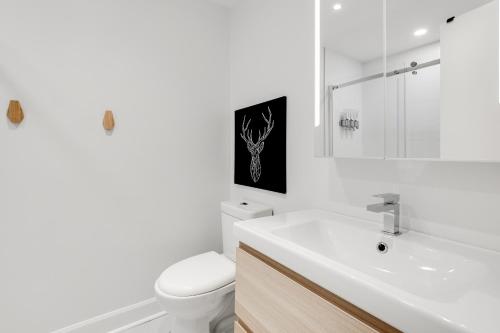 蒙特朗布朗Le Lightroom by Gestion ELITE的白色的浴室设有卫生间和水槽。