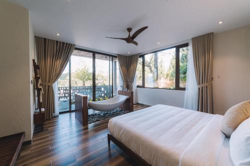 大叻大叻禅谷酒店的一间卧室配有一张床、一把椅子和窗户。