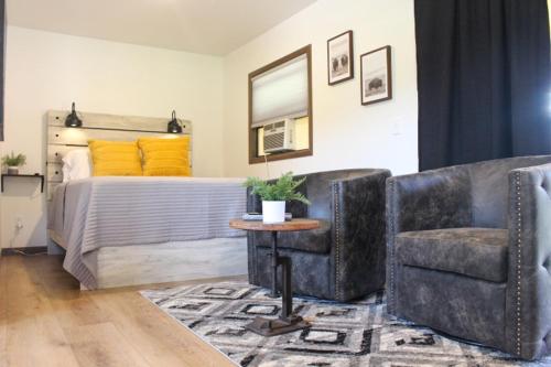 拉皮德城Cabin 5 at Horse Creek Resort的一间卧室配有一张床、两把椅子和一张桌子