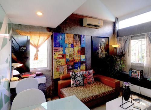 查龙普吉岛天堂旅馆的客厅配有沙发和墙上的绘画