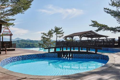 堤川市Club ES Jecheon Resort的湖畔带凉亭的游泳池
