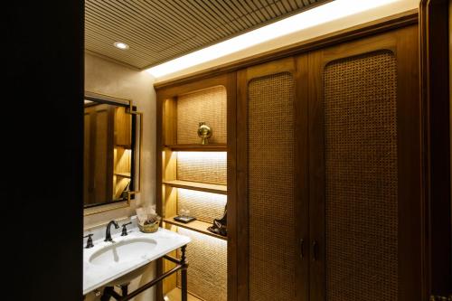 普吉镇Hotel Verdigris的一间带水槽和镜子的浴室
