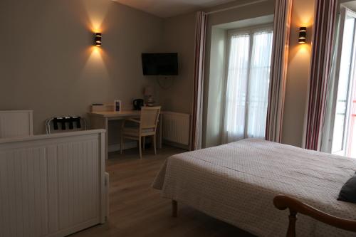 圣让-德吕兹卡帕格里酒店的一间卧室配有一张床、一张桌子和一张桌子