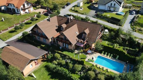 伏尔塔瓦河畔利普诺Apartments Lipno Serafin的享有带游泳池的房屋的空中景致