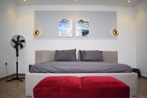 拉各斯Luxury Apartments的一间卧室配有一张红色的搁脚凳的床