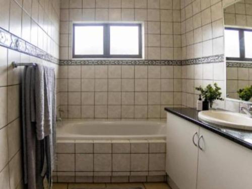 KelsoMarula Mews T17 Villa - Selborne Golf Estate的带浴缸和盥洗盆的浴室